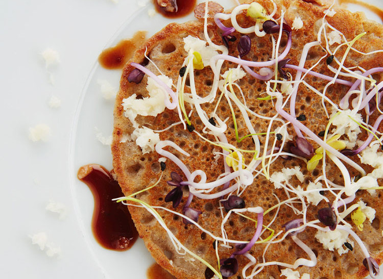 Pancakes made from oats and buckwheat with sprout mix and pear syrup.