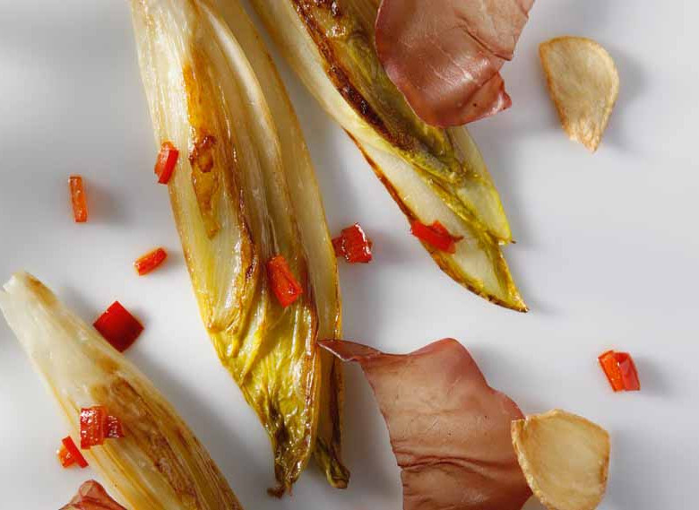Plancha of Belgian Endive with Bresaola, Garlic Chips, and Bell Pepper Strips